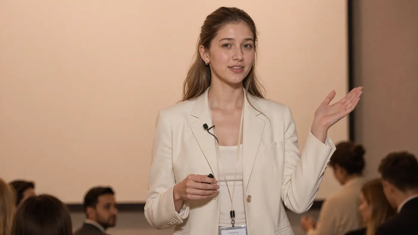 AI talent: a young woman in an ivory blazer presenting to an audience.