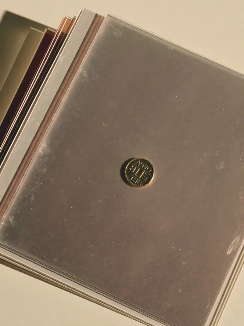 A grey folder with a small brass token resting on it, lit by soft side light, illustrating marketing incrementality.