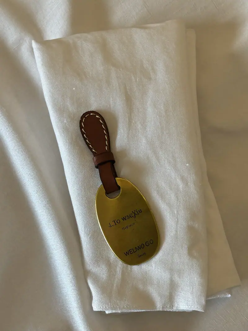 Folded hotel linen with a leather key sleeve and a brass welcome token, illustrating hotel marketing KPIs.