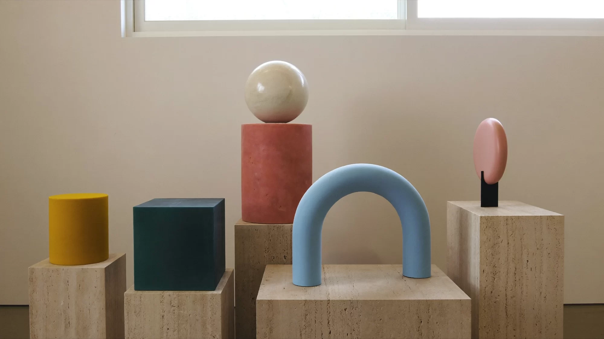 Sculptural objects in teal, coral, ivory and pastel tones on travertine plinths of different heights. Sample image created by Quiamo, a brand, marketing and media agency from India.