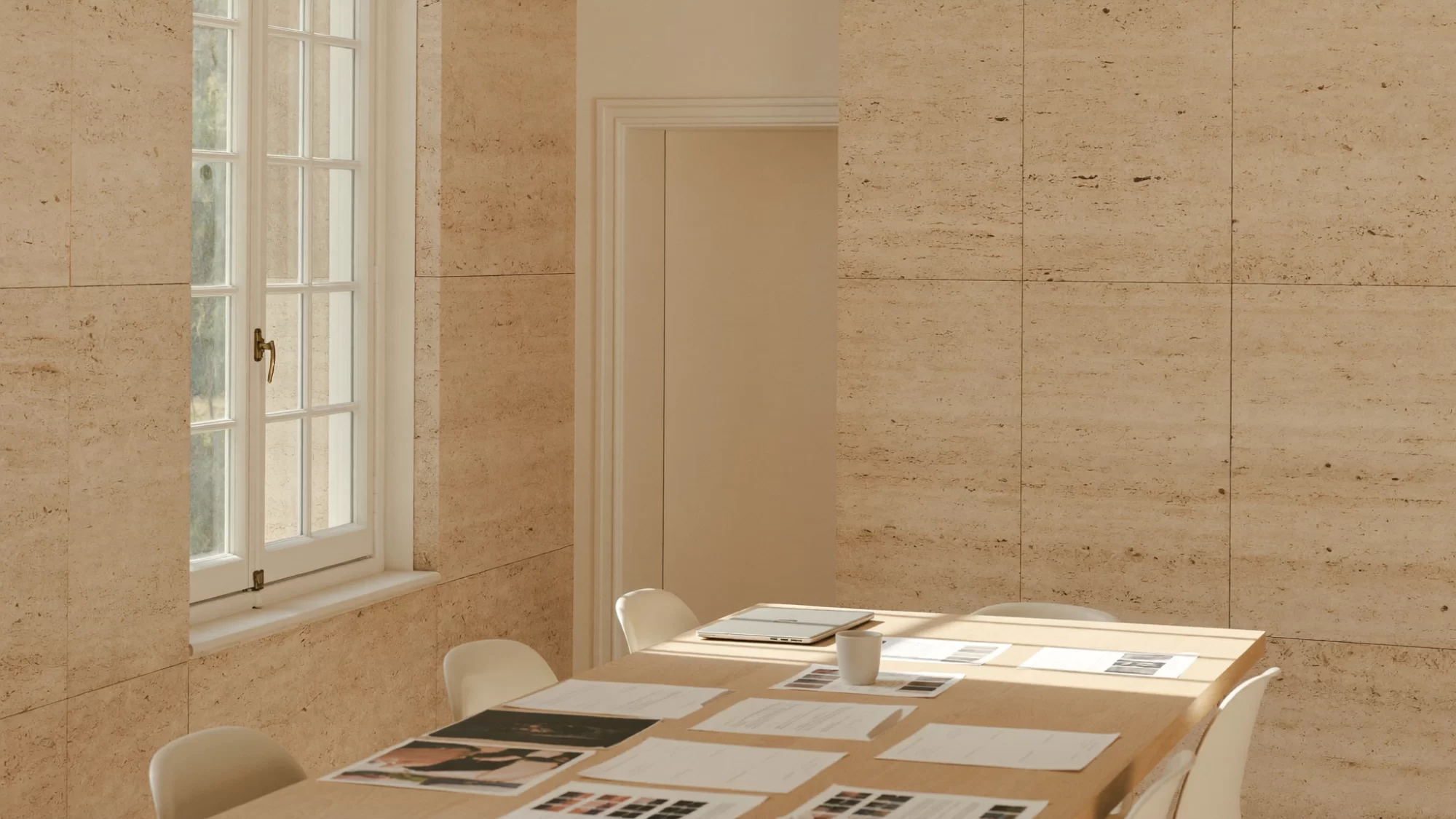 Un estudio de diseño tranquilo con maquetas fijadas en una pared de travertino, el espacio donde se ordenan los proyectos de marca y packaging.