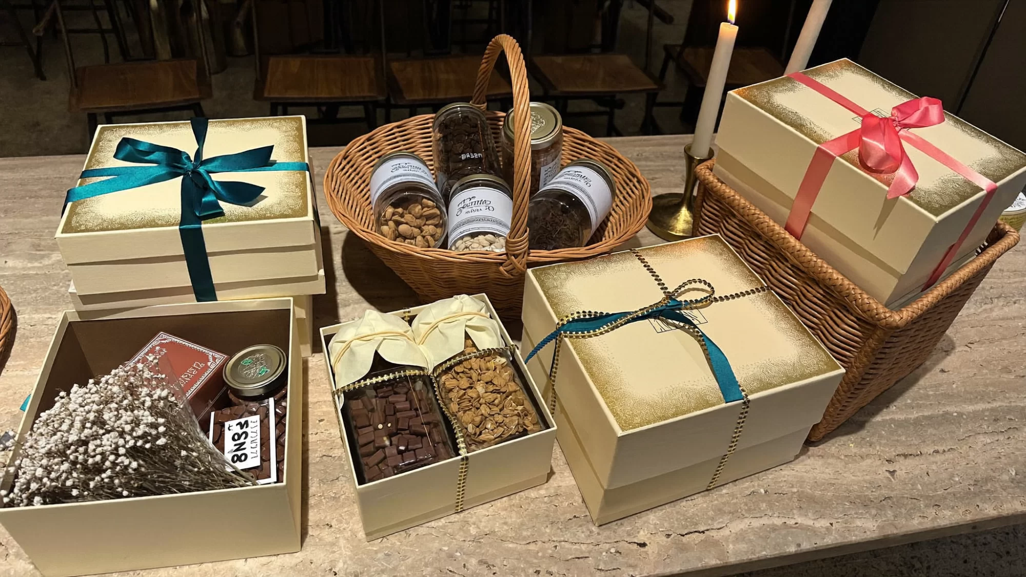 Festive gift hampers and boxes tied with teal and coral ribbons on a long travertine table. Sample image created by Quiamo, a brand, marketing and media agency from India.